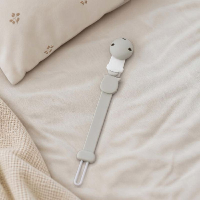 attache tetine pose sur le lit