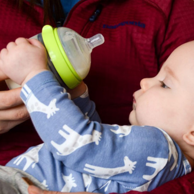 Bébé tient son biberon anis