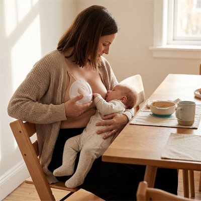Coquille d'allaitement maman assit a son bureau avec bebe