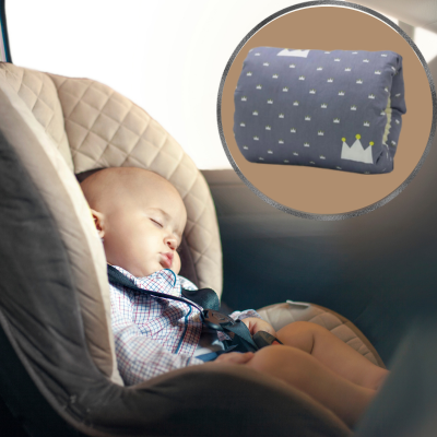 bébé dans une voiture qui dort dans le cosi avec le coussin allaitement