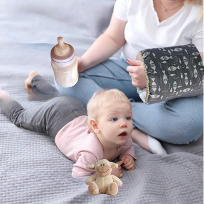 Maman au lit avec coussin d'allaitement brassard donne biberon