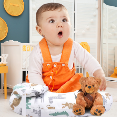 Bébé assis contente dans sa chambre dur son coussin d'allaitement foret