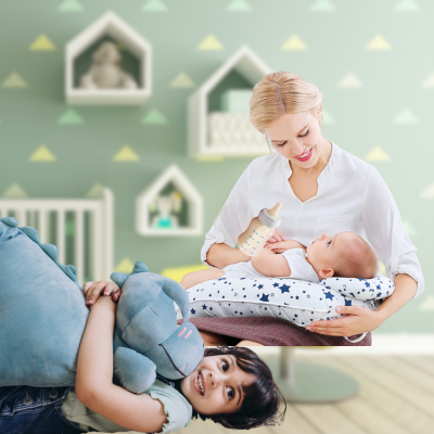 Maman assis avec coussin d'allaitement Star sur ses genoux qui donne biberon