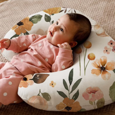 Coussin d'allaitement fleuri bébé allongé sur le coussin.