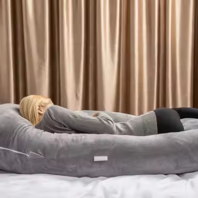 Sur son coussin de grossesse, une maman qui sommeil dans sa chambre.