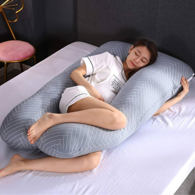 Maman qui est bien soutenue dans son coussin de grossesse grise rayé