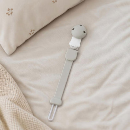 attache tetine pose sur le lit