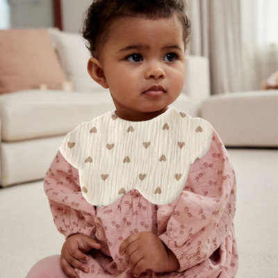 Bavoir bebe Mimi Chou enfant assie sur tapis