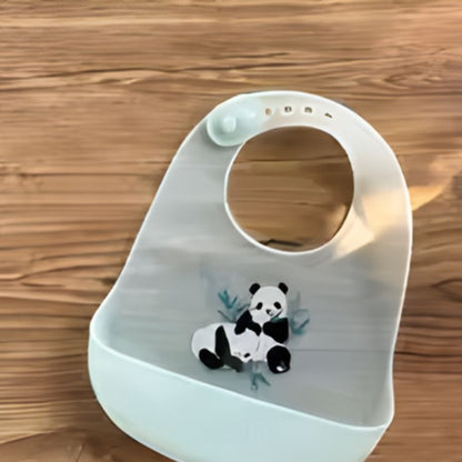 Bavoir silicone lavable EcoPocket posé sur table en bois