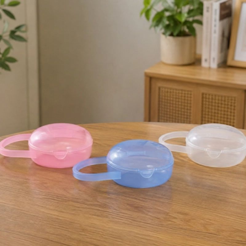 Boite a tetine​ bleu rose blanc sur la table