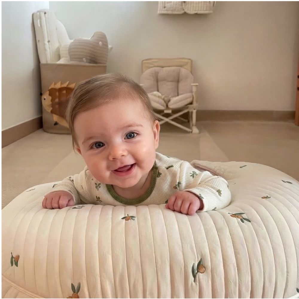 Coussin allaitement bebe souriant allonger sur son coussin