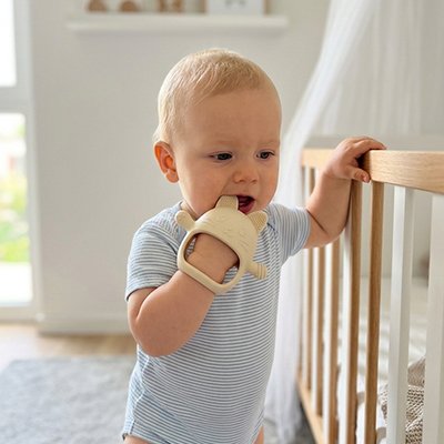 anneau de dentition bébé enfant debout devant son berceau