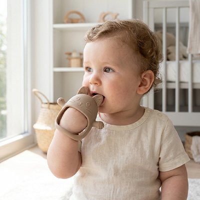 anneau de dentition bébé met dans sa bouche assise chambre