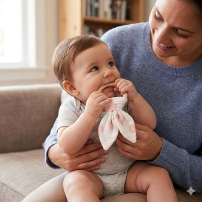 anneau de dentition bebe assise sur genou maman