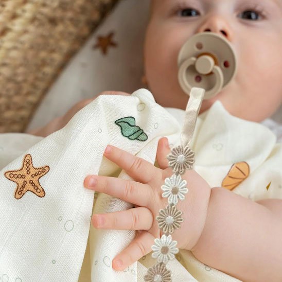 Attache tetine accrocher a son pyjama bebe allonger dans sa bouche sucette 