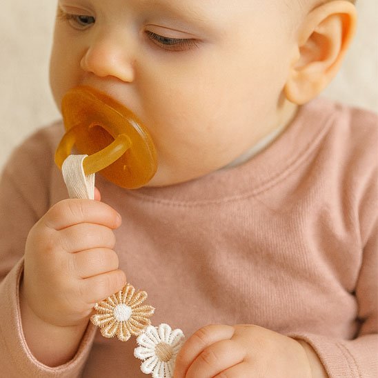 Attache tetine avec la sucette dans bouche bebe