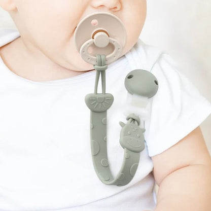 Attache tetine sur le body de bebe