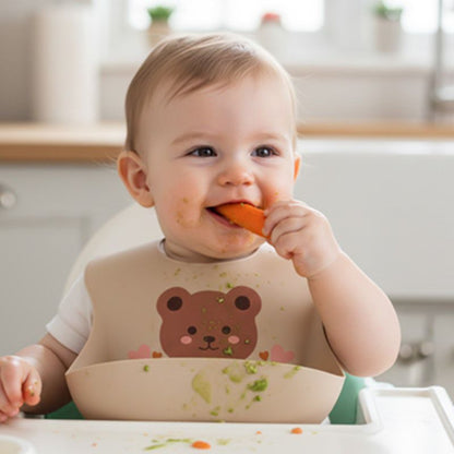 bavoir bebe enfant assise a table mange legume