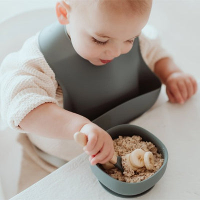 Bavoir bébé qui mange ses cereales