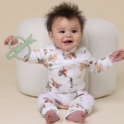 bebe assise par terre avec Anneau de dentition  