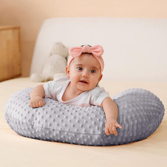 bebe allonger dessus son Coussin d'allaitement  souriant