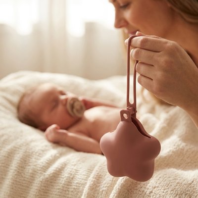 Boite a tetine maman tient dans sa main regarde bebe