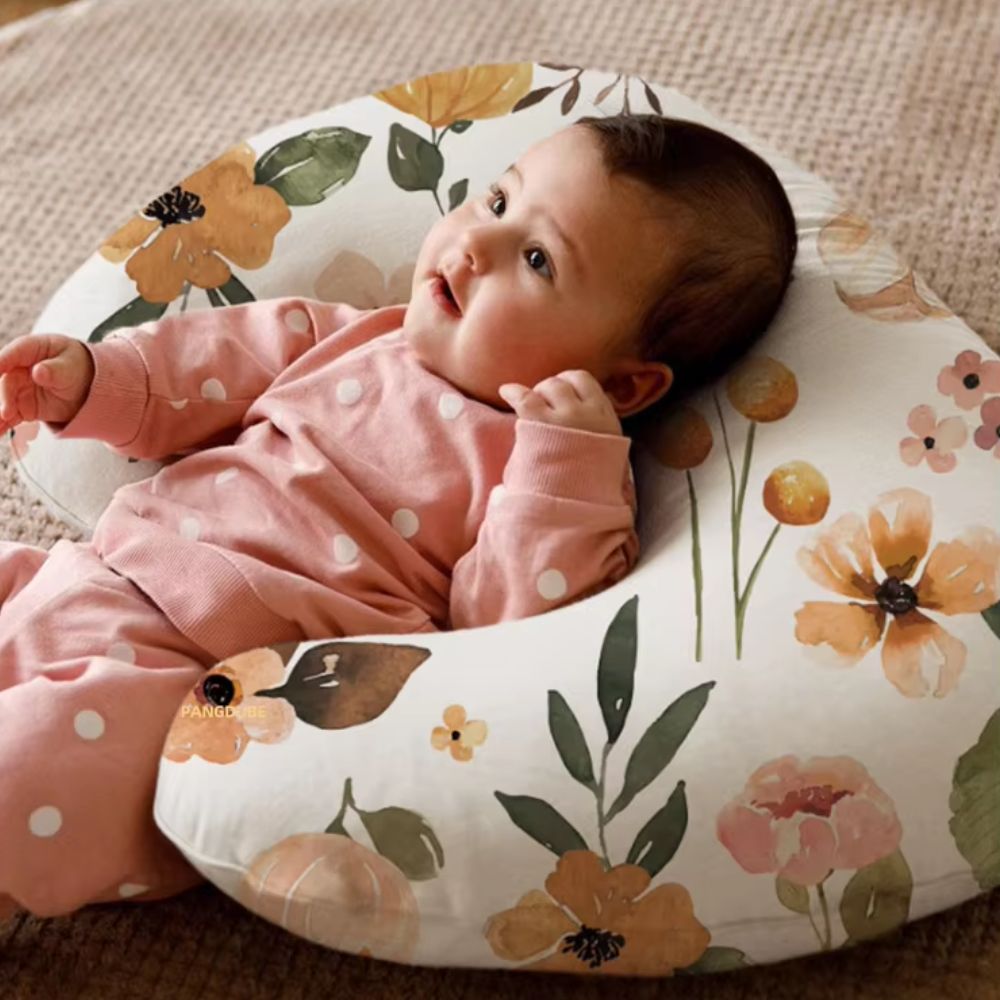 coussin d'allaitement fleuri bébé allongé sur le coussin.