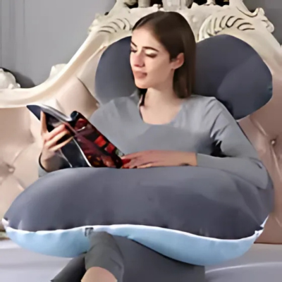 Maman avec son coussin de grossesse bicolore au lit