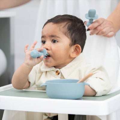Couvert bébé qui porte a sa bouche sa fourchette