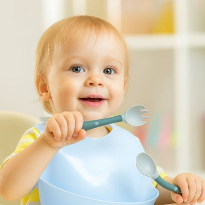Couvert pour bebe​ enfant souriant qui mange