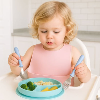 Couvert pour bebe  fille regarde son assiette