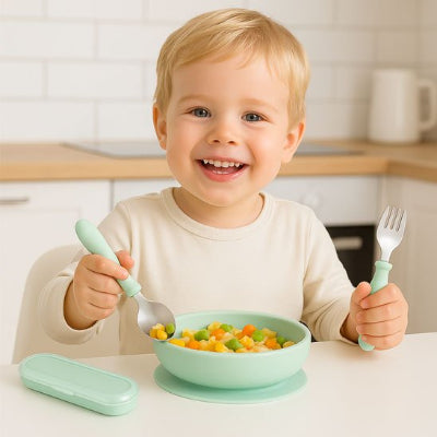 Couvert pour bebe garcon souriant devant son assiette