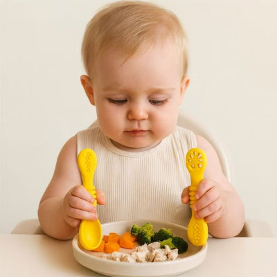 Couvert pour bebe qui regarde son assiette