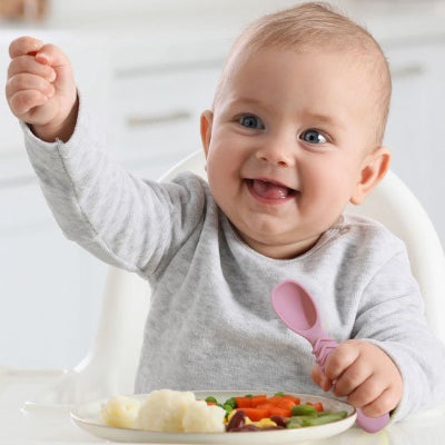 Couvert pour bebe tient sa cuillere rose