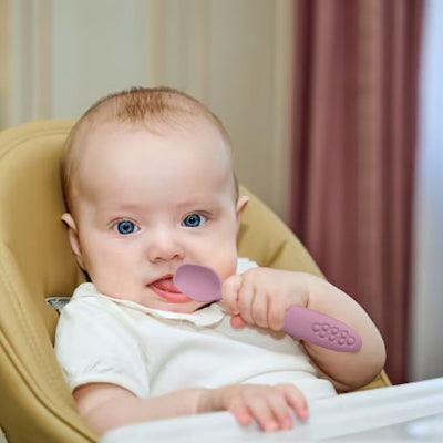 Cuillere bebe assit dans cosy avec sa cuillere