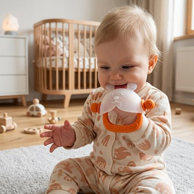 enfant assise avec son anneau de dentition bébé dans sa chambre
