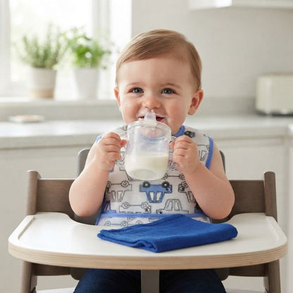 Enfant boit son lait, assis, bavoir bébé ultra-absorbant