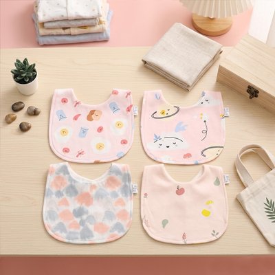 ensemble Bavoir bébé rose imprimé posé sur commode
