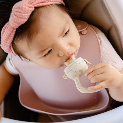 Grignoteuse bébé assit dans sa chaise haute