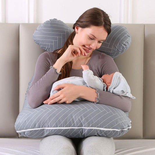 maman assise dans son canape joue avec son bebe sur Coussin de grossesse
