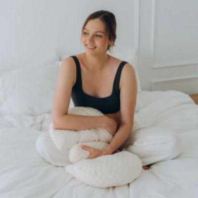 maman assise sur lit avec son coussin grossesse