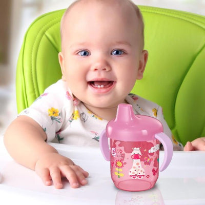 verre bebe qui sourrit devant son verre rose