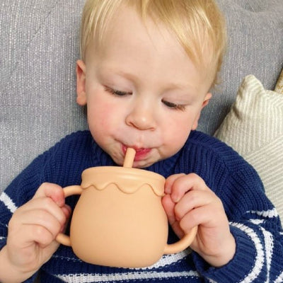 Verre bebe rose garcon tient sa poignee