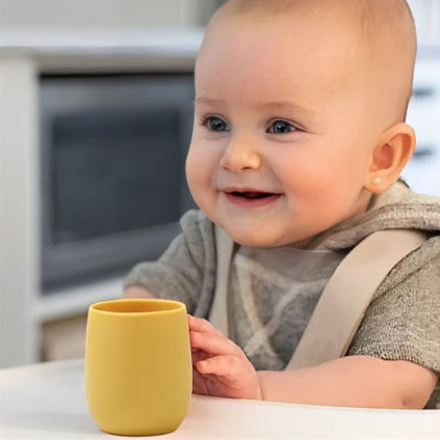 verre bebe souriant devant son verre jaune