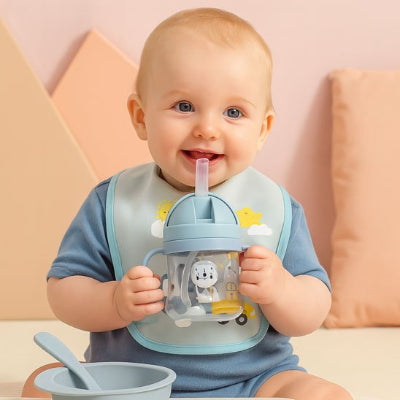 Verre bebe sourit en tenant son gobelet.