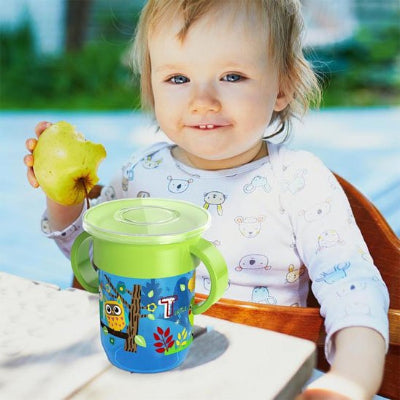 Verre pour bebe assit devant son gobelet